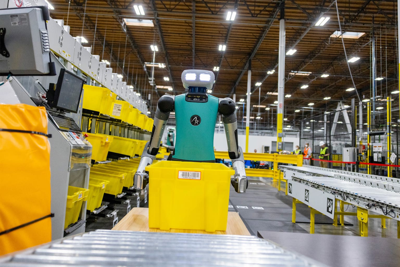 Amazon robot carrying a bin from conveyor belt.