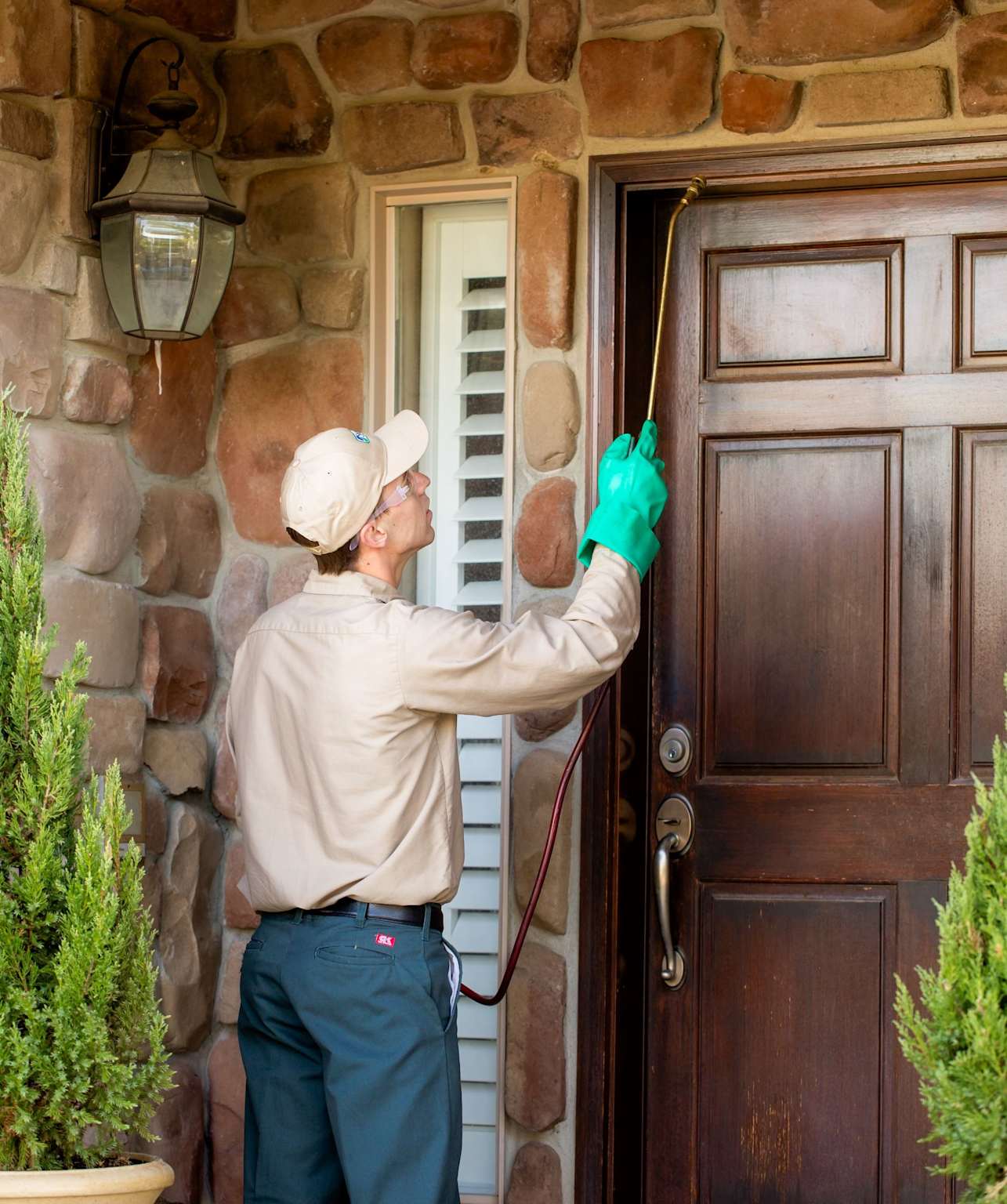 Pest control technician spraying home entrance Toronto Nomore Pest residential