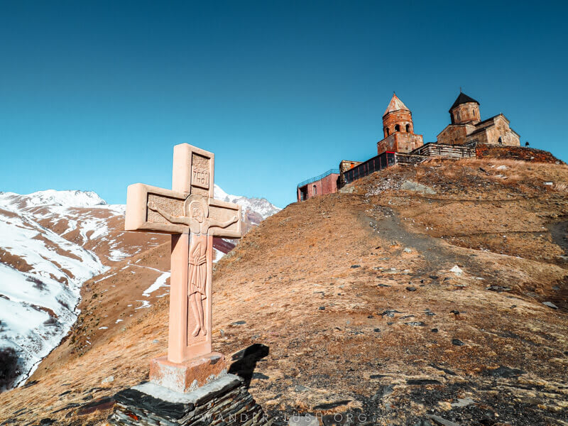 Gergeti Trinity Church overlooking Stepantsminda with Caucasus Mountains — Georgia tourism
