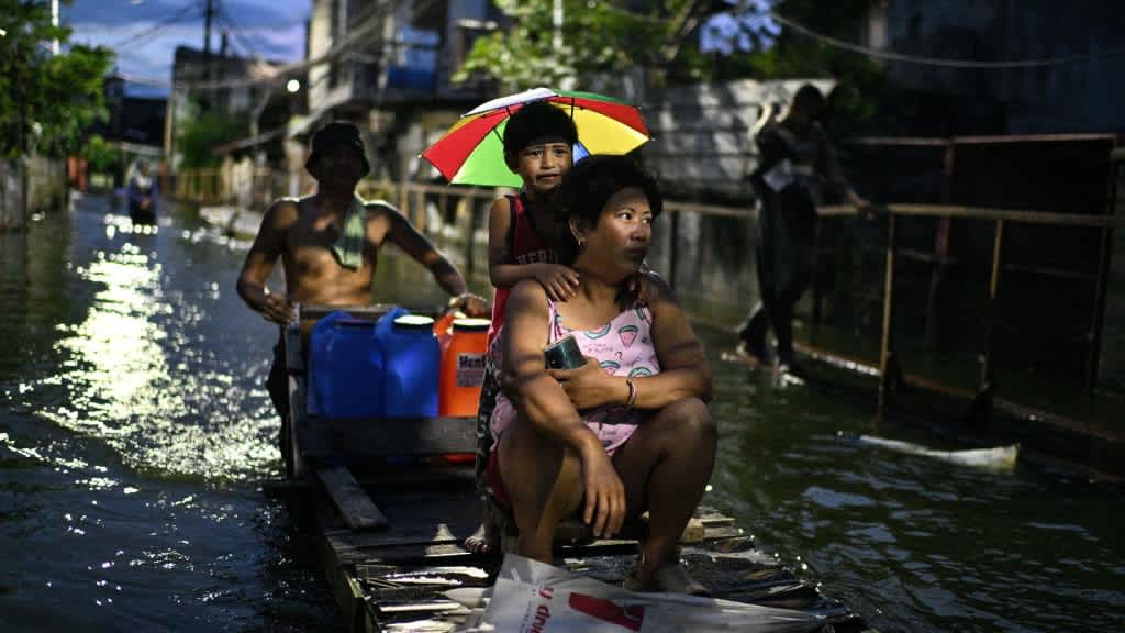 Family evacuating amid typhoon floodwaters