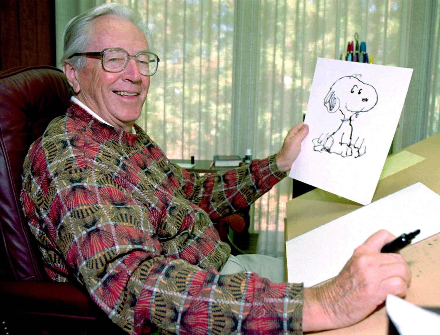 Charles Schulz at drawing desk