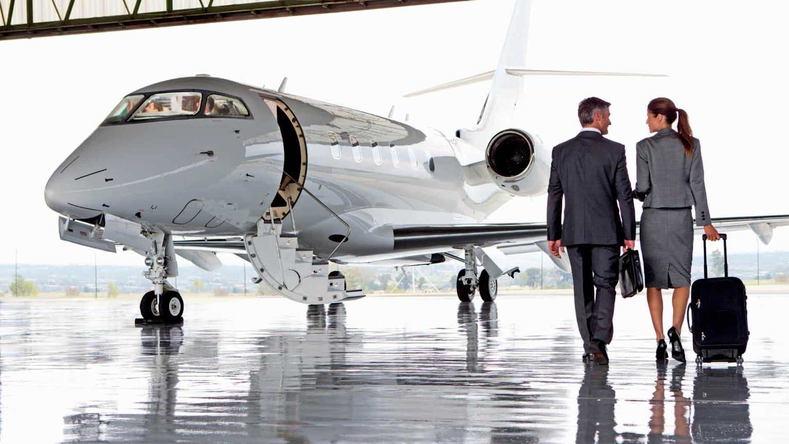 Business professionals with luggage boarding private jet