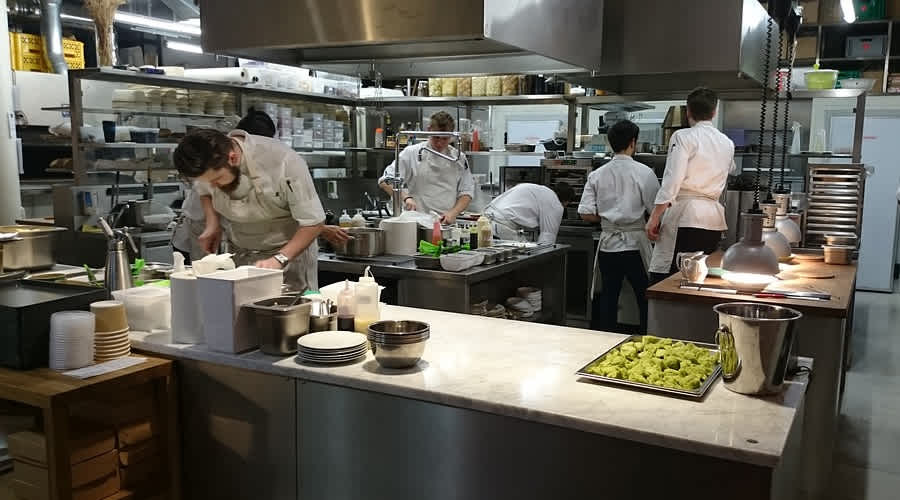 Equipe atuando em cozinha industrial com fluxo operacional padronizado