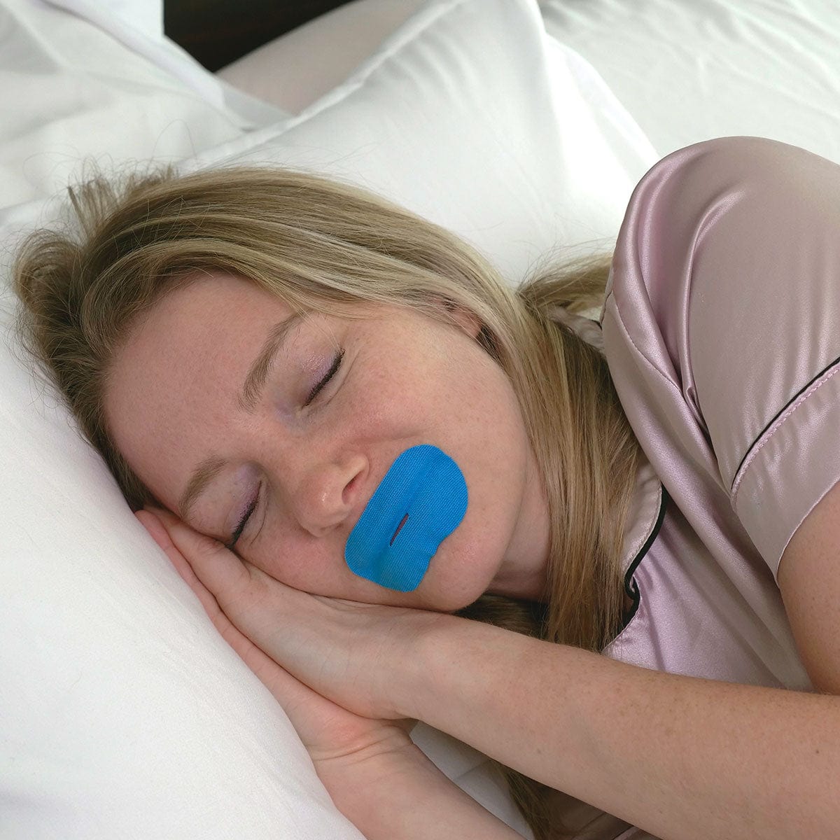 woman sleeping with blue mouth tape for sleep apnea — showing mouth taping at night and the airway risk for unscreened adults