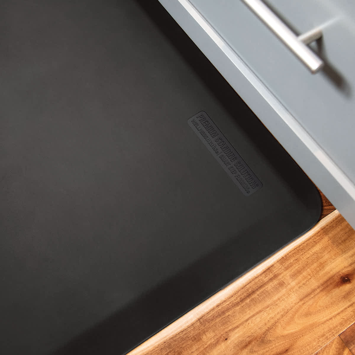 WellnessMats Original Anti-Fatigue Floor Mat &ndash; black mat beside kitchen cabinet