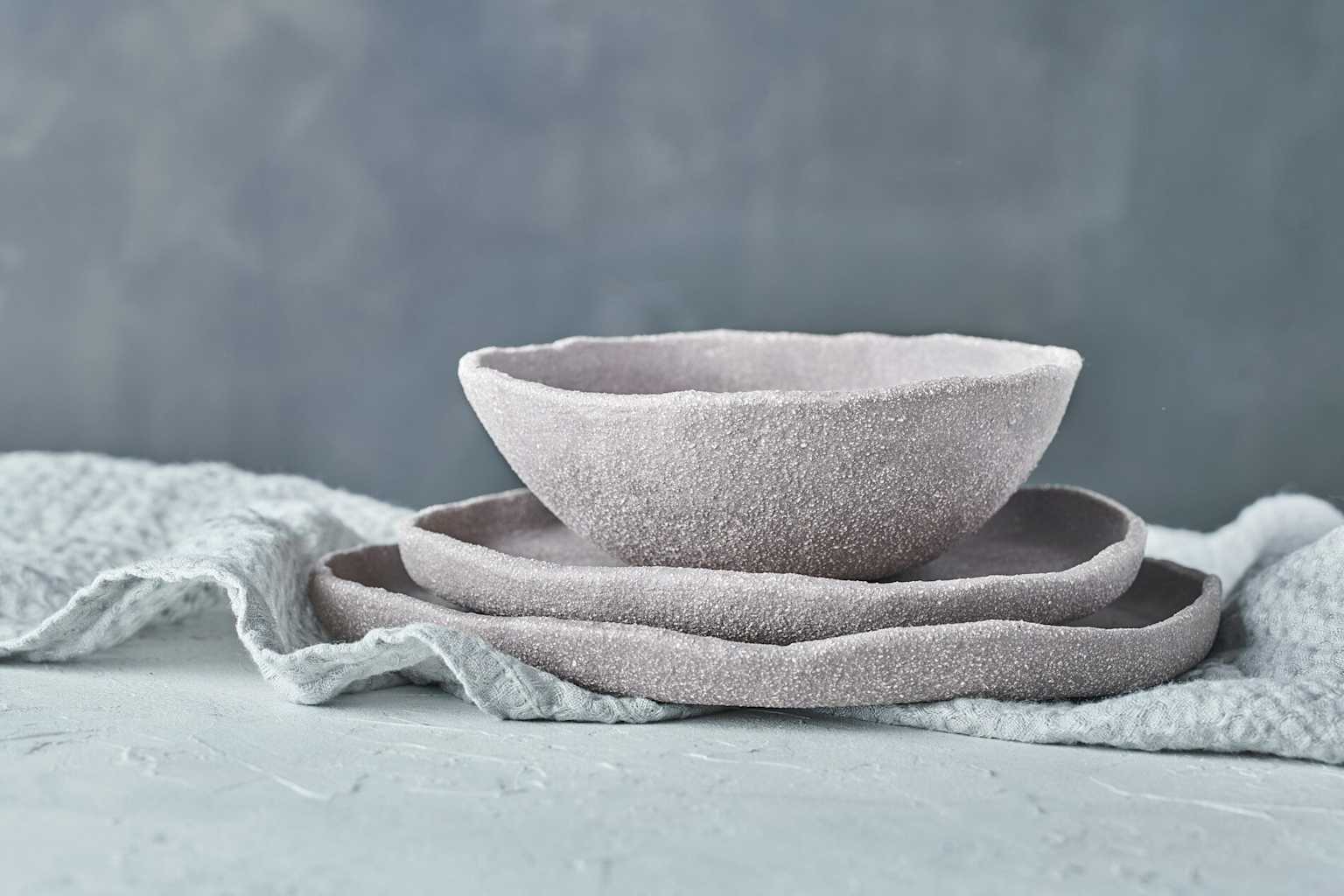 Stacked handmade ceramic bowls in soft gray tones