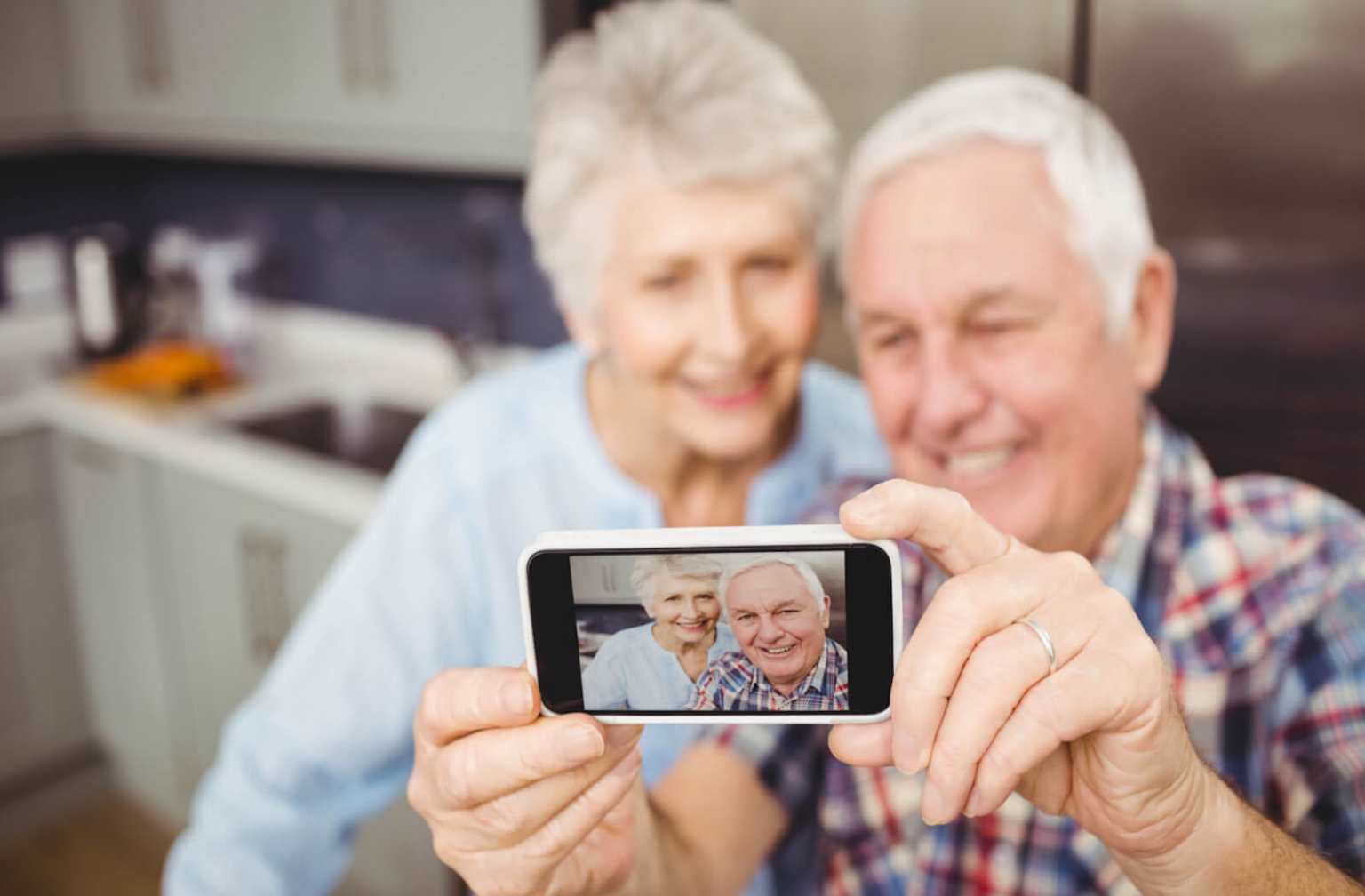 Couple senior prenant une photo avec un smartphone