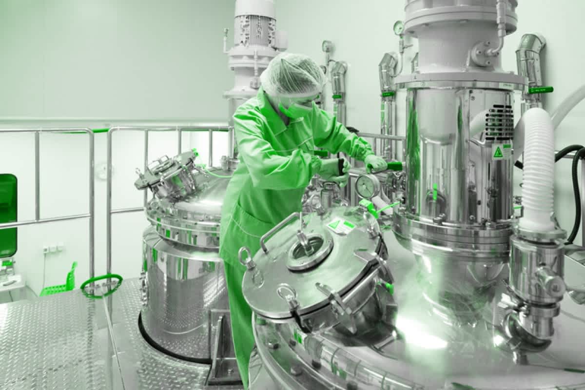 Pharmaceutical manufacturing worker in cleanroom facility — pharmaceuticals and healthcare sector