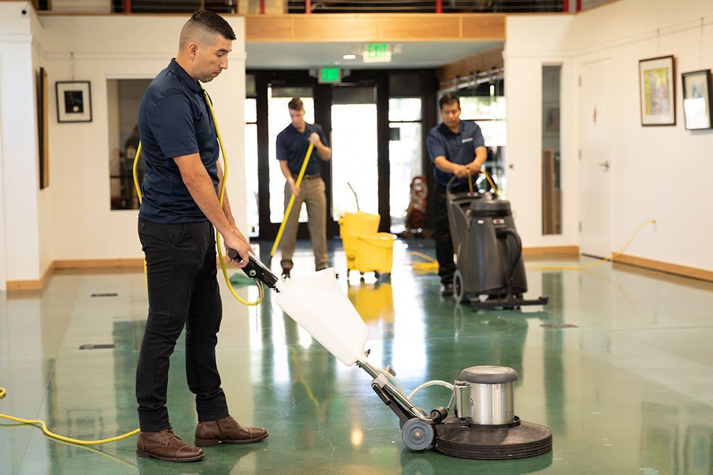 Professional janitorial team cleaning and polishing a commercial floor