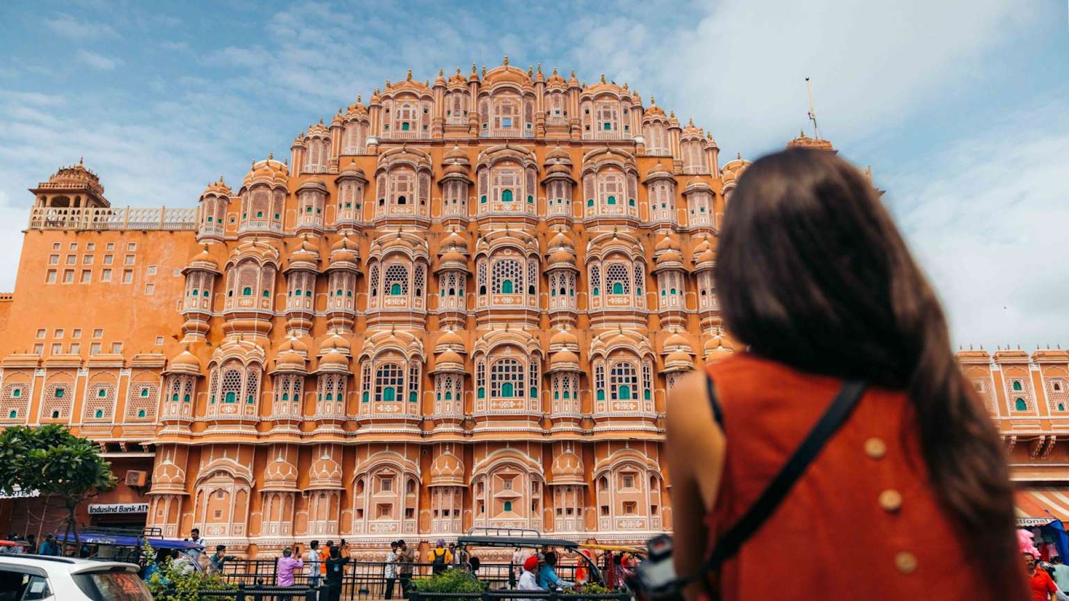 Traveler in front of an ornate historic palace, representing culture-led premium travel