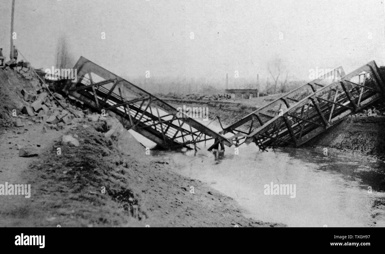 Collapsed bridge lying broken in a river after wartime destruction