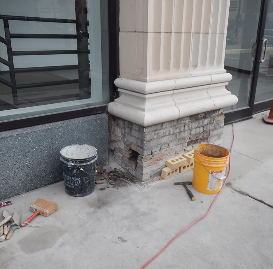 Stone and brick building facade restoration work in progress