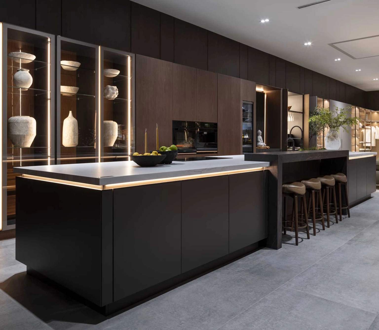 Modern luxury kitchen with dark wood cabinetry, island, and upscale finishes