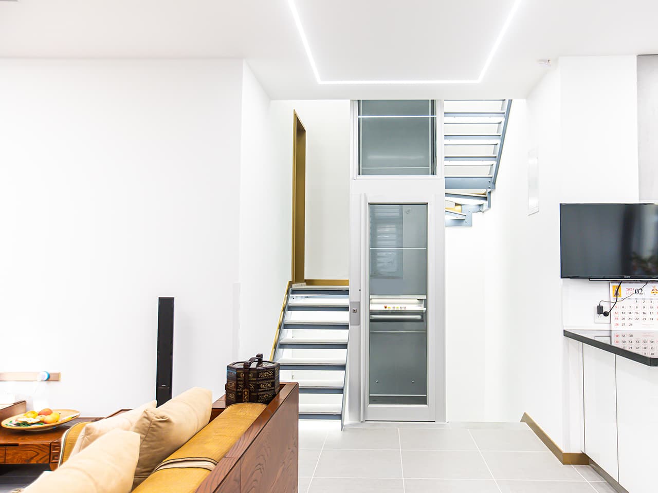 Compact home lift near staircase