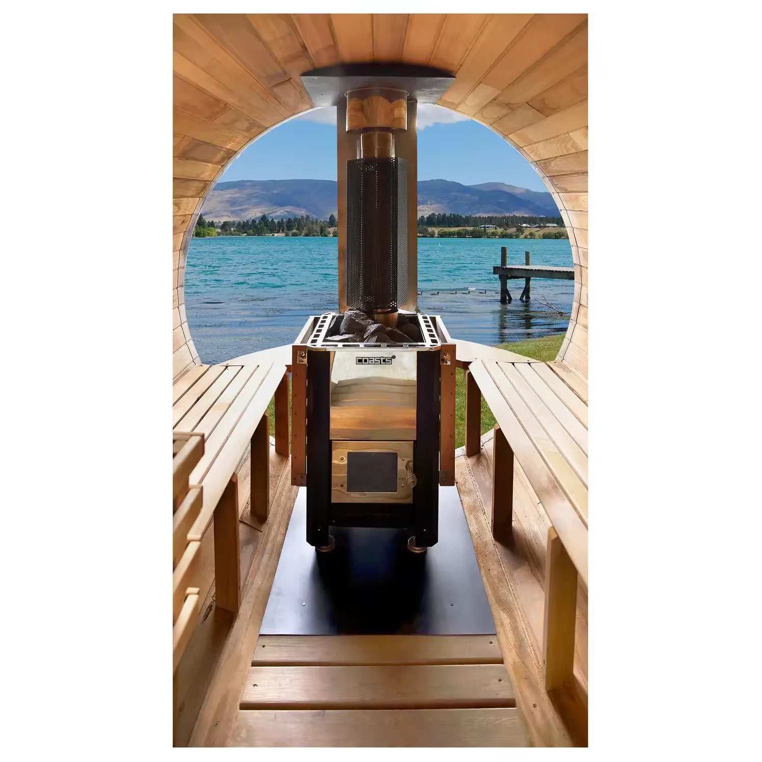 Coasts stainless steel wood-burning sauna stove installed in a barrel sauna interior with wooden benches and lake view through the window