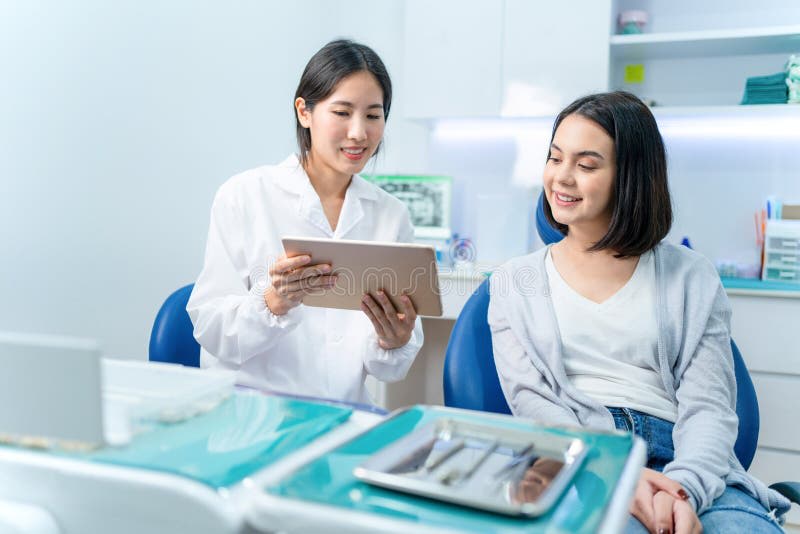 Dentist showing a treatment plan on a tablet to a patient