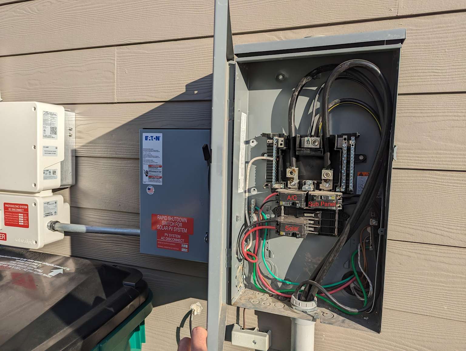 A whole-home energy monitor being installed inside a residential electrical breaker panel