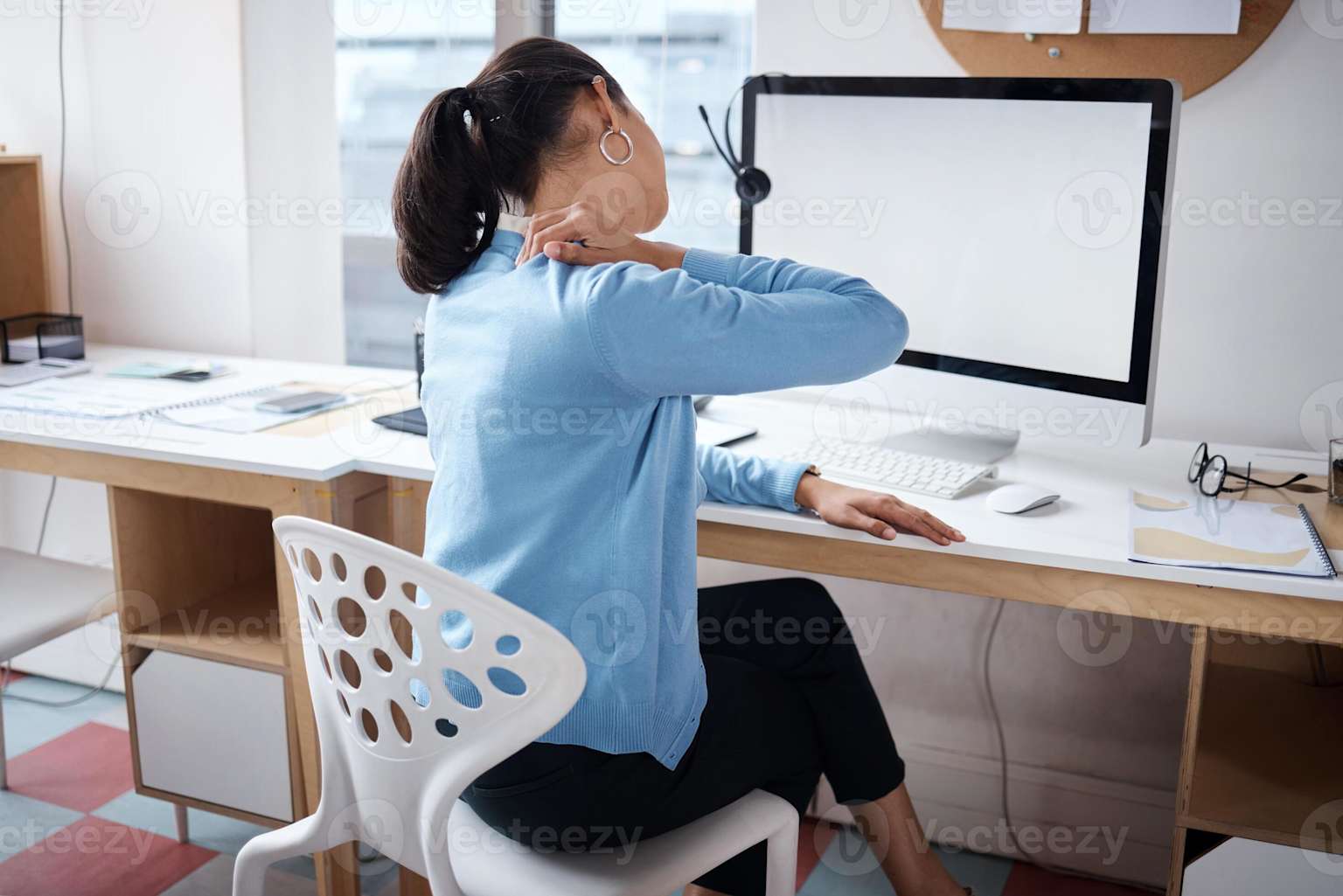Mulher com dor no pescoço sentada na frente do monitor — postura incorreta e cansaço visual