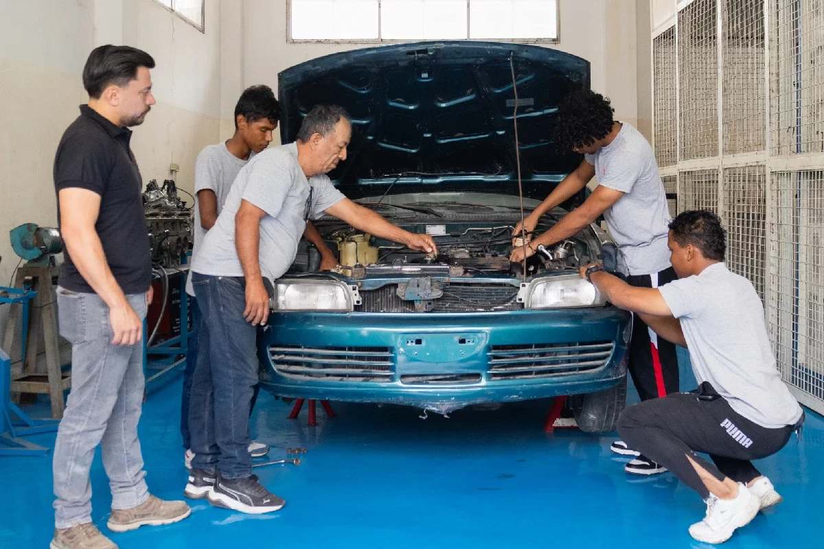 Mecánicos reparando motor de auto en taller Ecuador