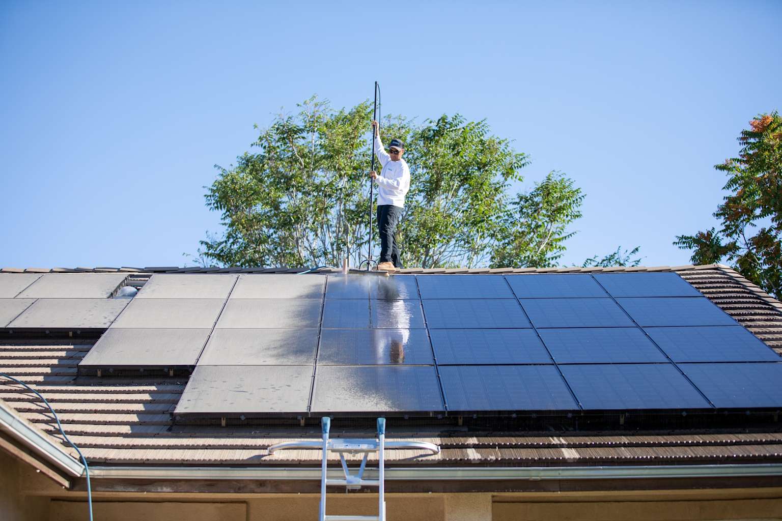 Technician cleaning solar panels on rooftop in Antelope Valley