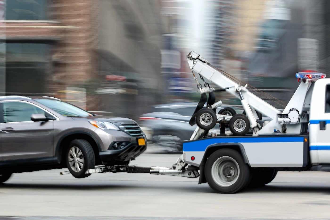 Tow truck hauling a car through Ottawa city streets