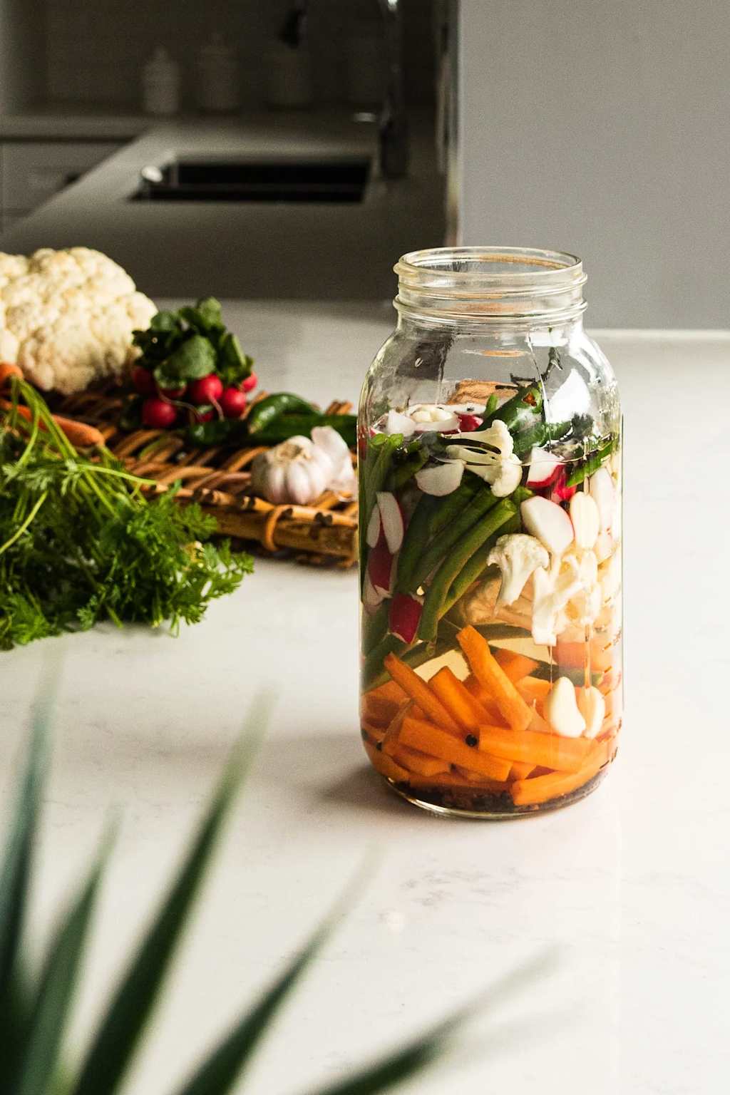 Großes Glas mit buntem fermentierten Gemüse – Karotten, Blumenkohl, Paprika