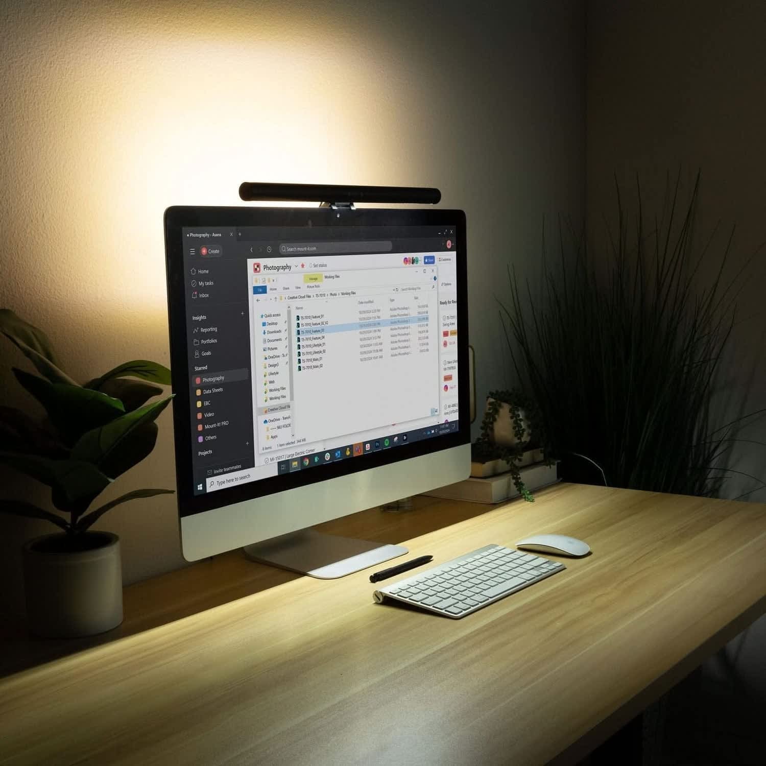 Monitor light bar mounted on top of an iMac illuminating the desk surface without creating screen glare