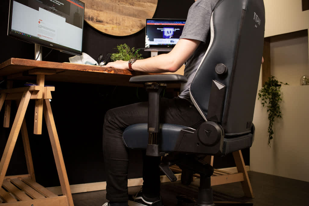Gamer in sedia ergonomica con postura corretta davanti a doppio monitor