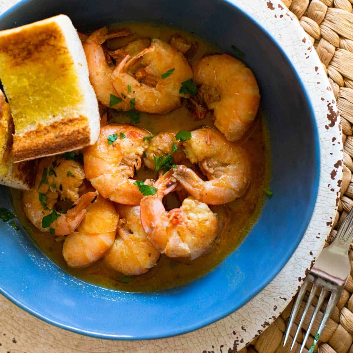 Garlic butter shrimp served with bread and fork