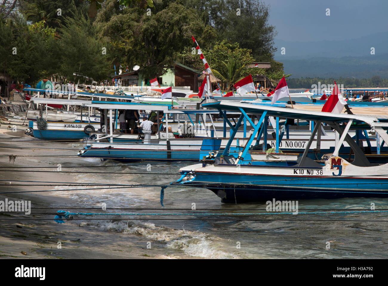 Bangsal Harbour, Lombok — boats docked at the pier with Gili Islands in the background