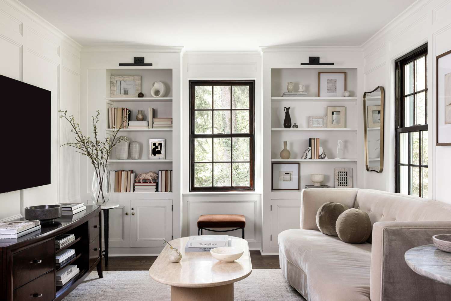 Beautifully styled bookshelves flanking windows in a modern living room