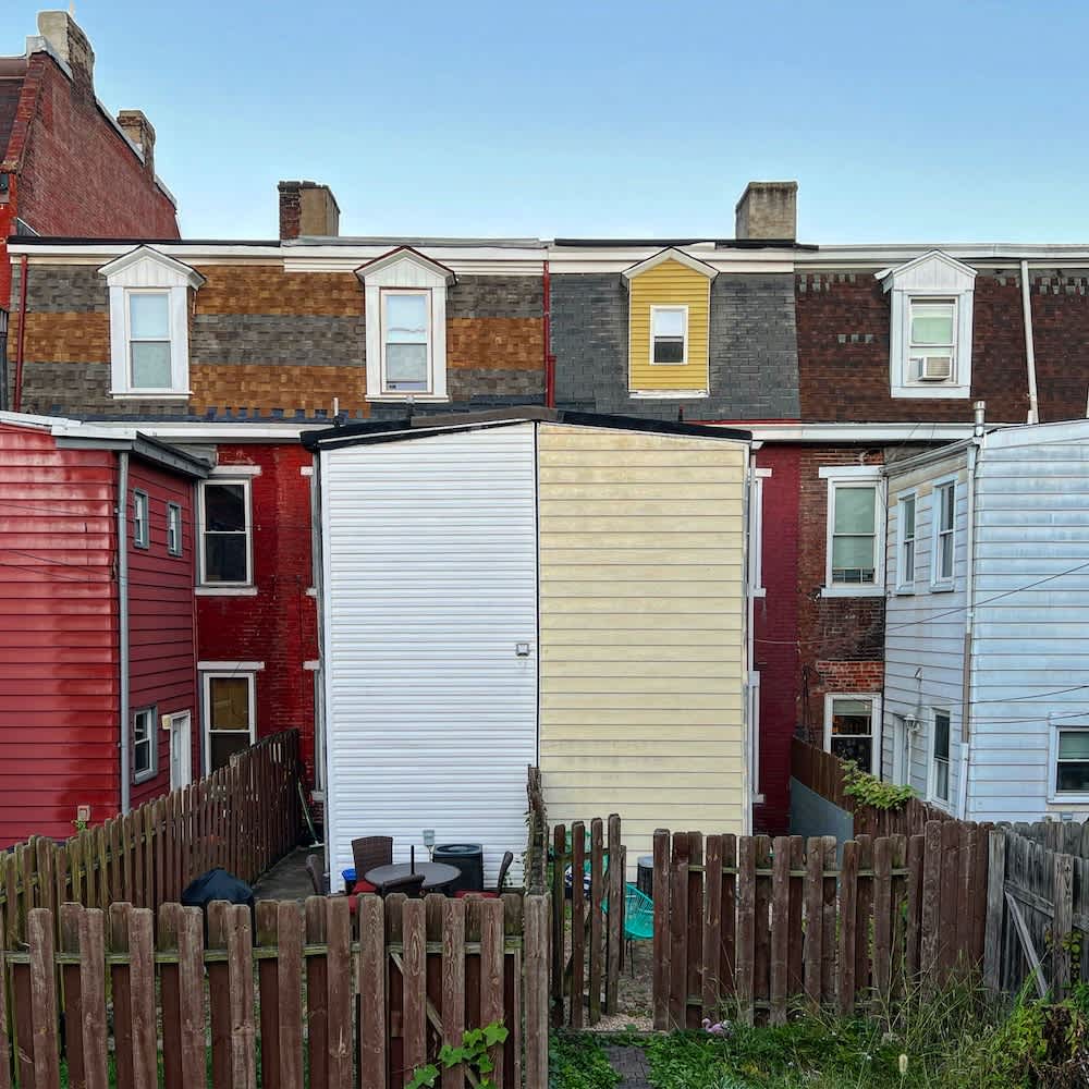 Colorful attached row houses with varied siding in a Pittsburgh neighborhood