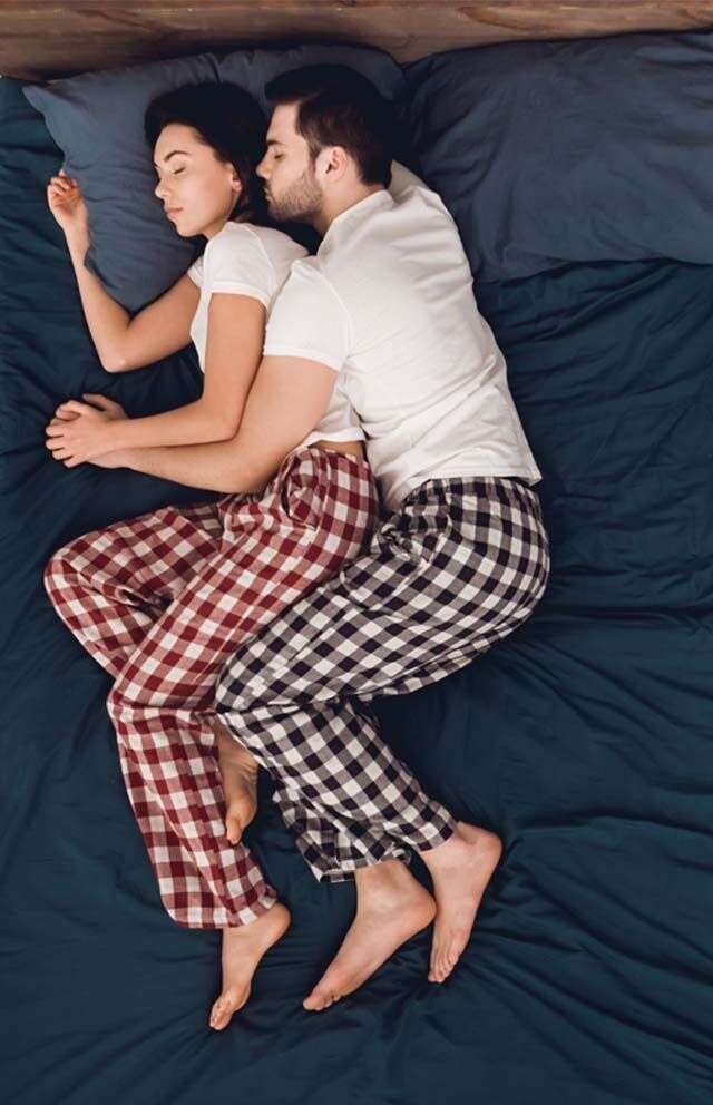cuddling positions — couple in comfortable sleeping embrace overhead