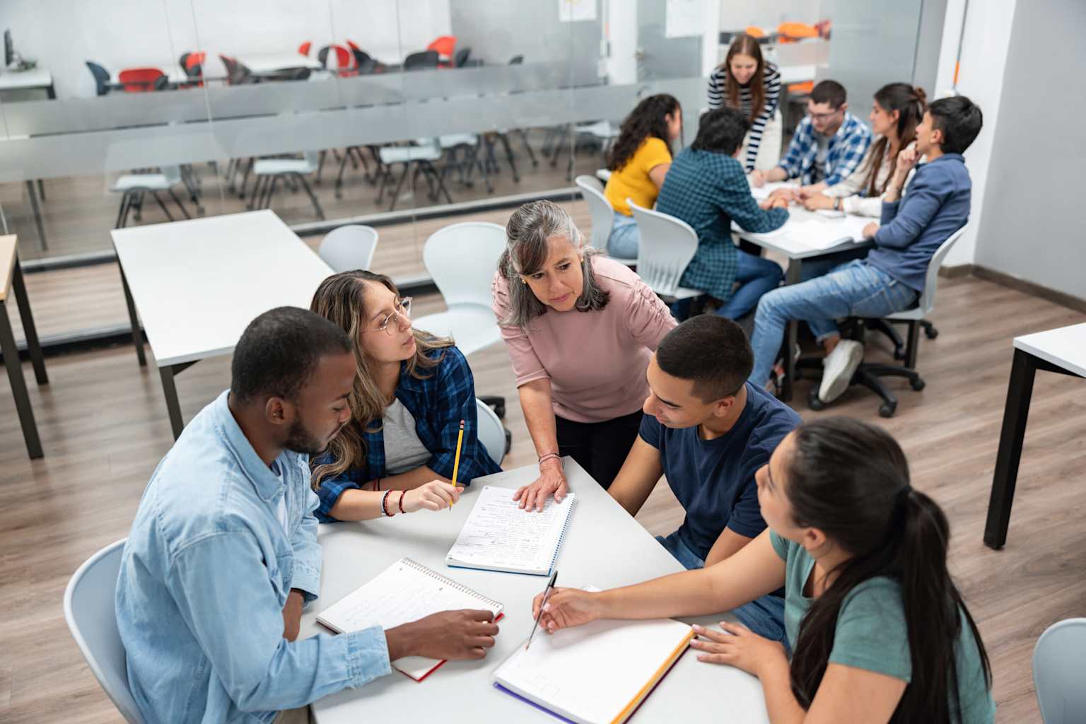 Students collaborating with a teacher in a modern classroom