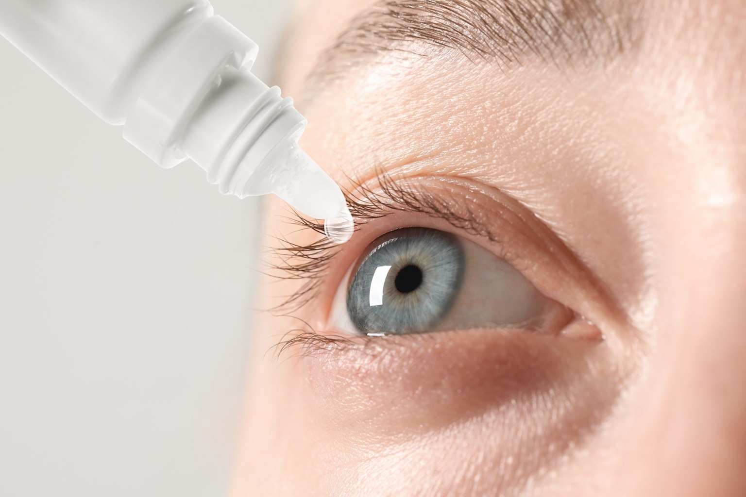 Woman applying eye drops