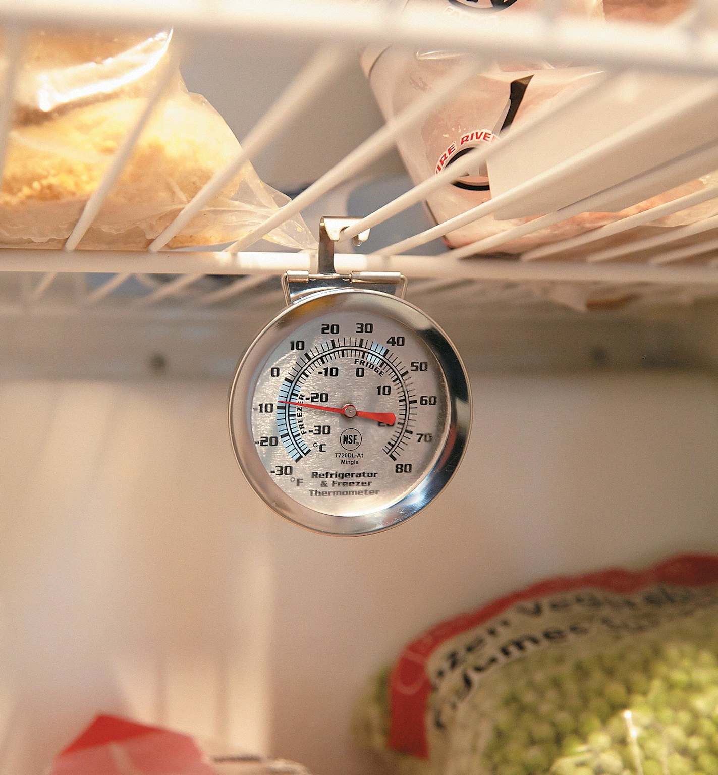A hanging thermometer checking the exact internal temperature of a refrigerator