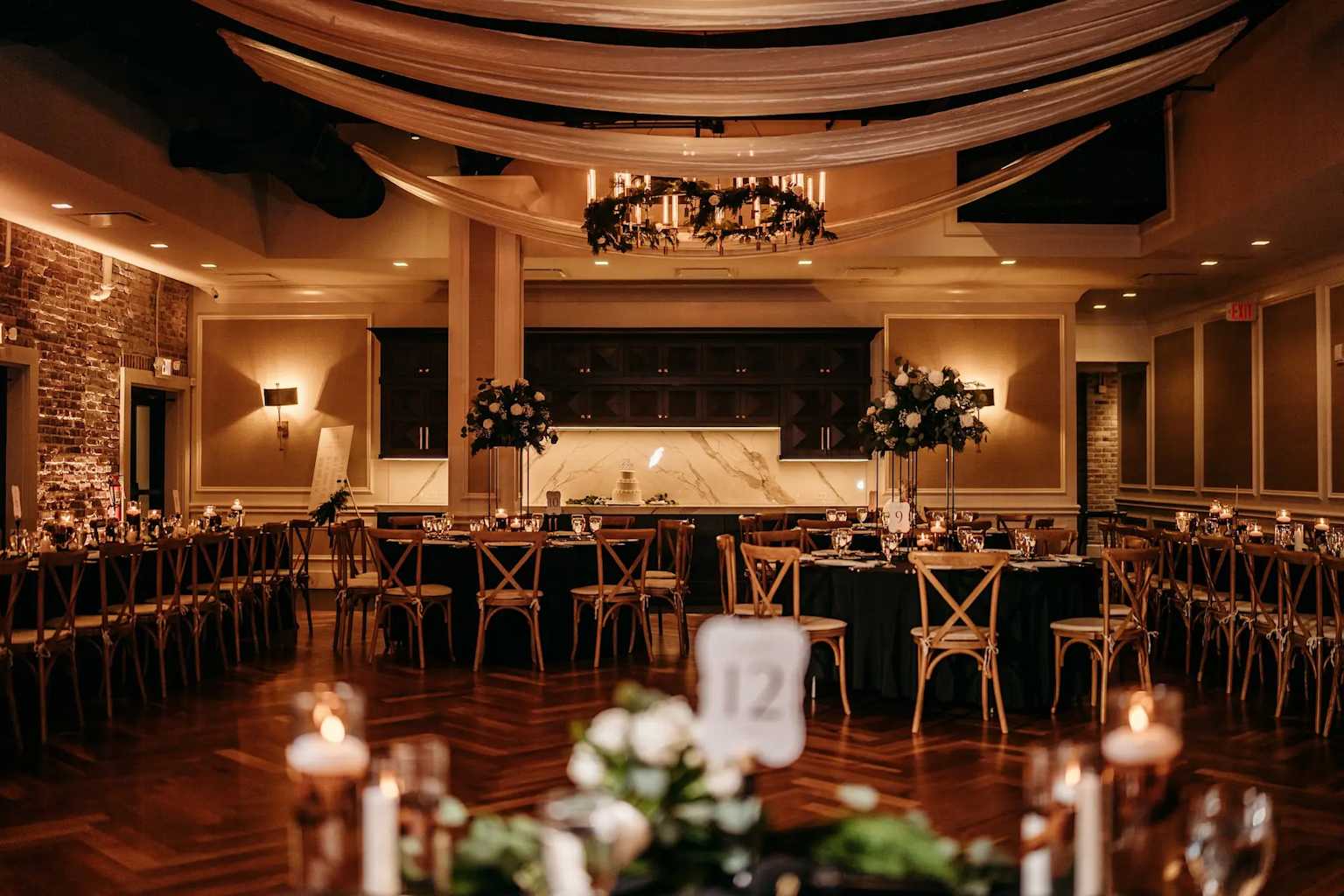 Elegant event venue with draped ceiling and long wooden tables