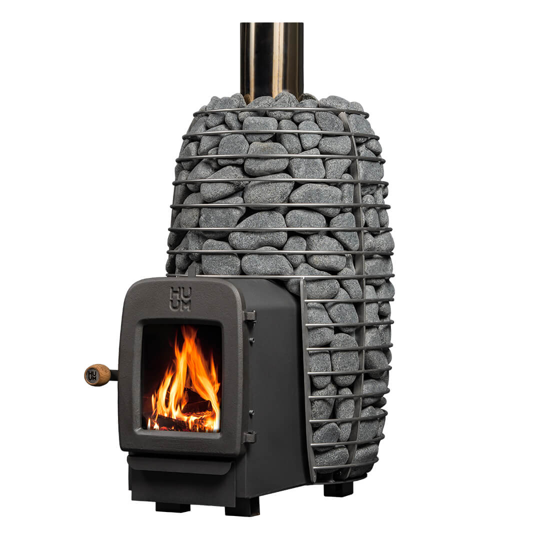 HUUM Hive Heat wood-burning sauna stove with cylindrical stone cage loaded with rocks and fire burning inside the firebox