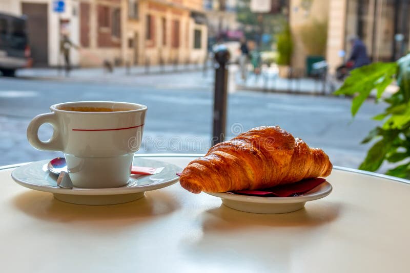 Coffee and croissant on cafe table