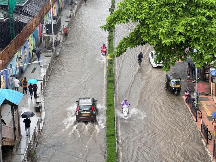 Vehicles moving through flooded street conditions during Maharashtra monsoon rainfall