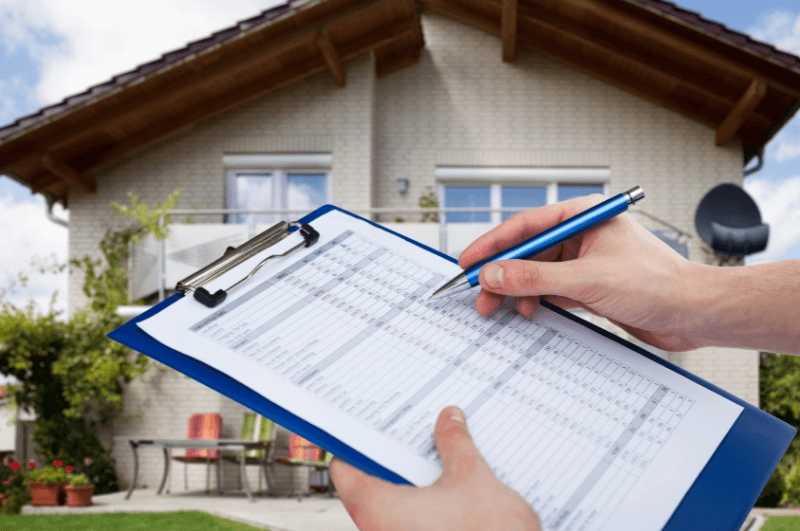 Home inspector holding a clipboard during a property visit