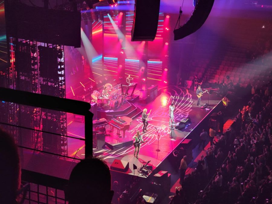 Journey performing at SNHU Arena with dramatic stage lighting