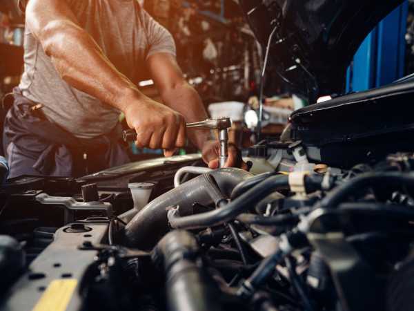 Mecânico inspecionando motor de carro na oficina