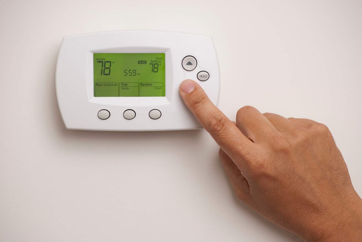Setting a digital thermostat to 78 degrees for optimal summer energy savings