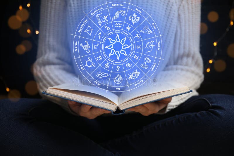 Woman reading horoscope with zodiac imagery
