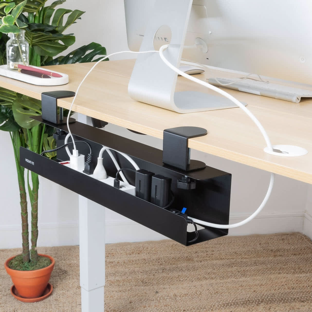 Under-desk cable management tray neatly routing cables away from the desk surface in a home office