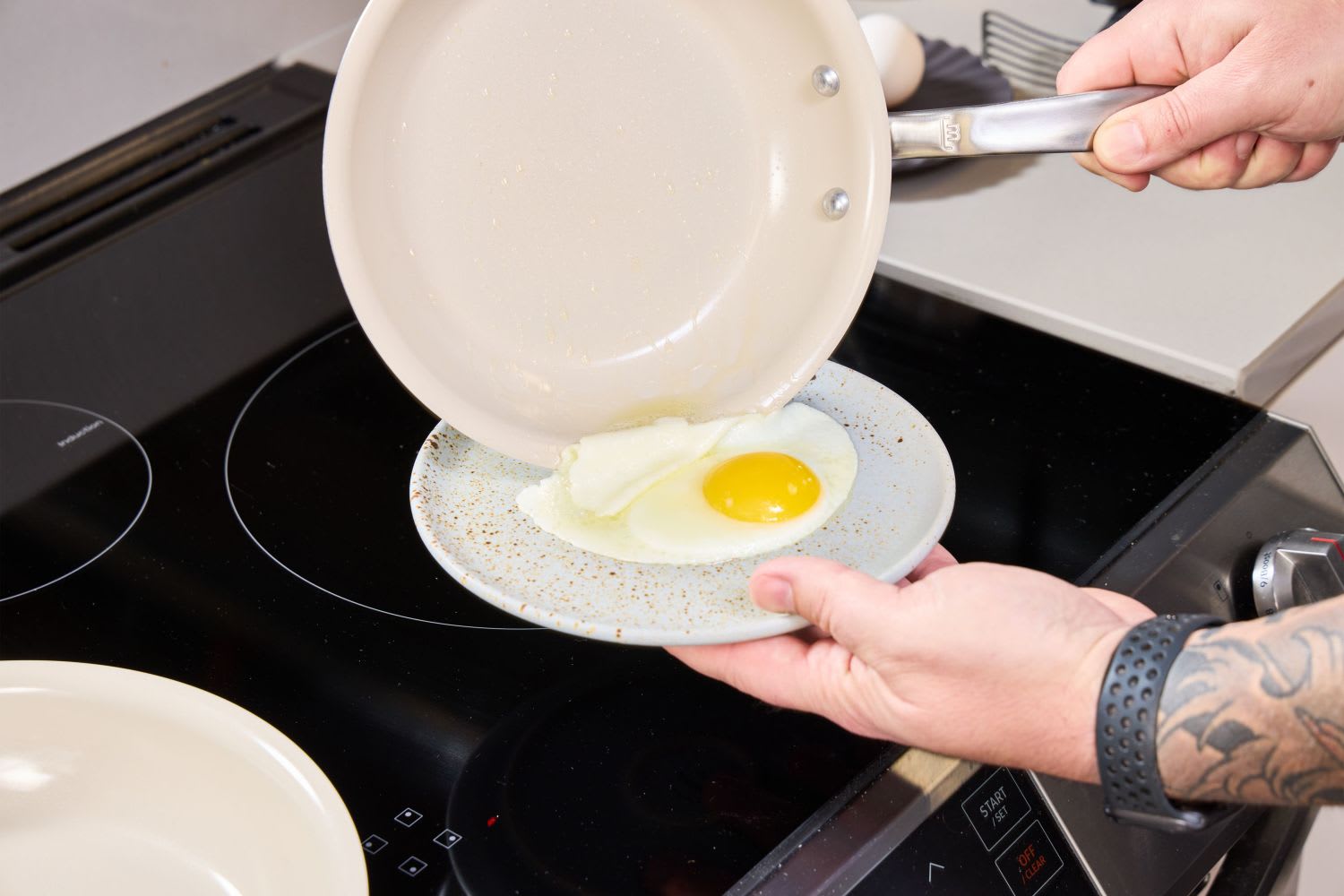 Fried egg flipping from nonstick pan onto plate