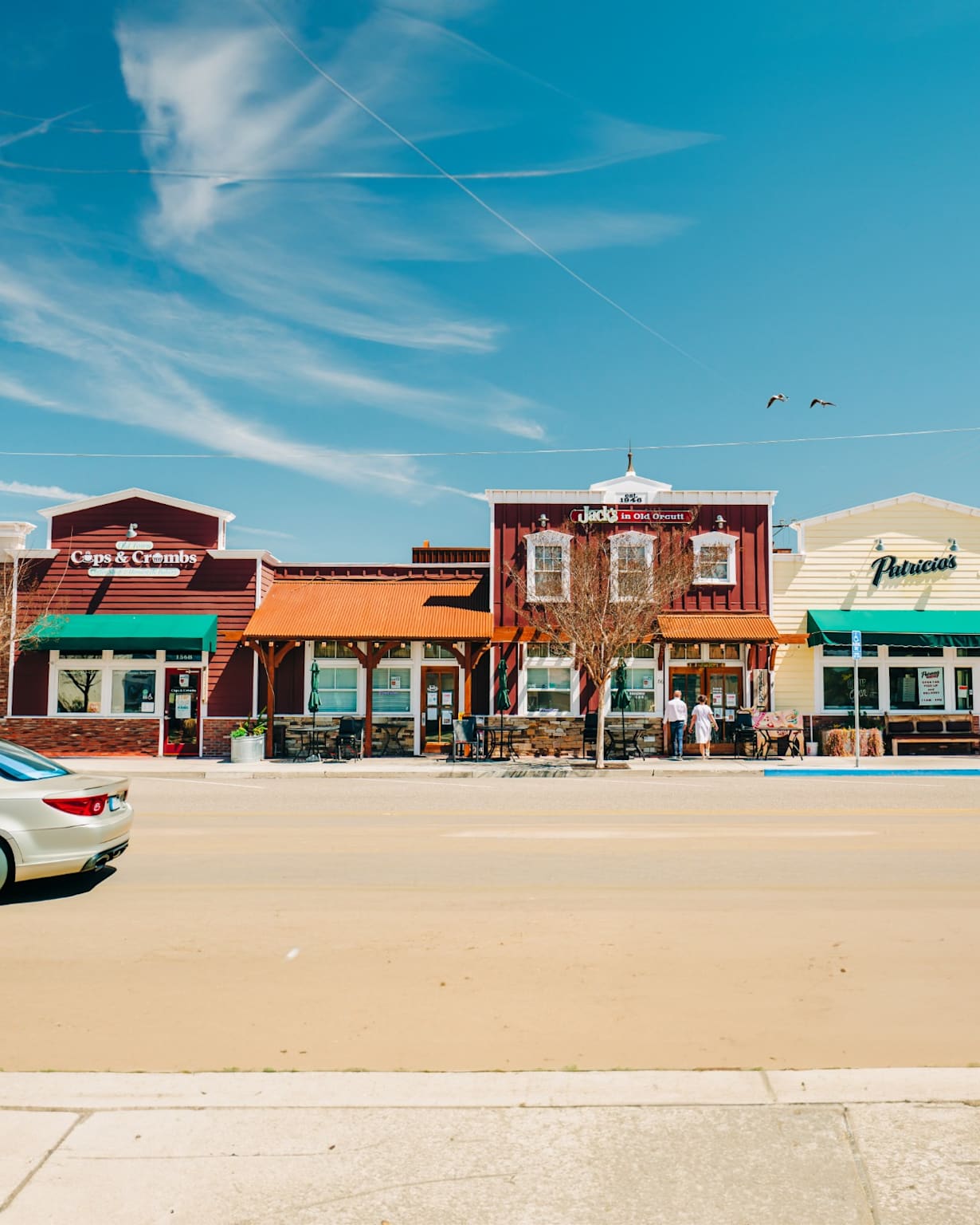 Wide street scene in Orcutt, California, featuring colorful storefronts and outdoor seating