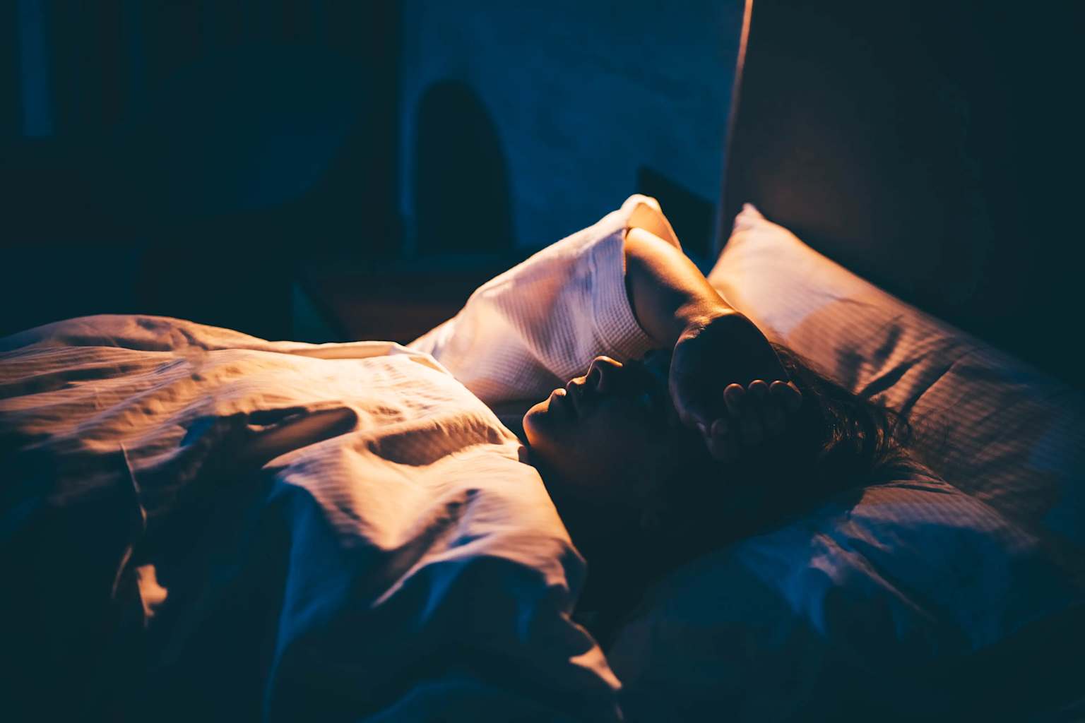 Person lying awake in bed at night unable to sleep — 3AM insomnia