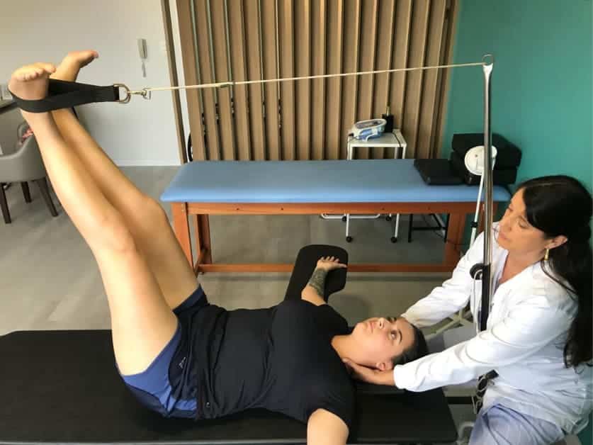 Sessão de RPG Souchard - terapeuta auxiliando paciente com postura terapêutica